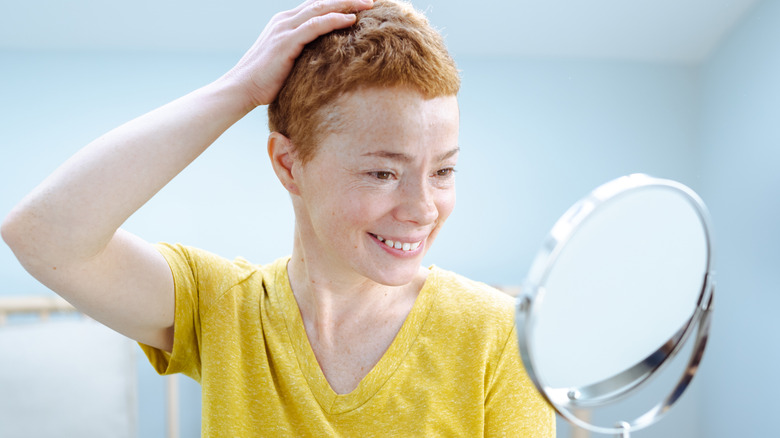 Woman smiling at makeup mirror