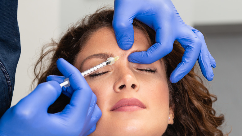 Woman receiving Botox injection between her eyebrows