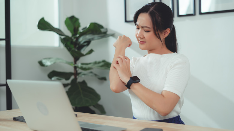 Woman scratching her arm