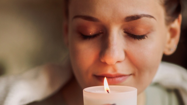 woman eyes closed enjoying candlelight