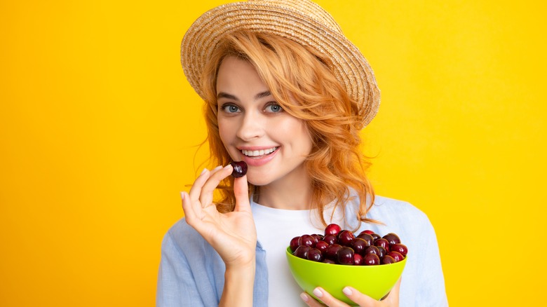 smiling woman holding cherries