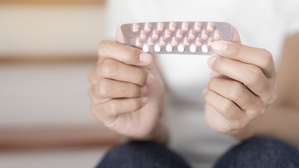 Woman's hands holding pack of birth control pills