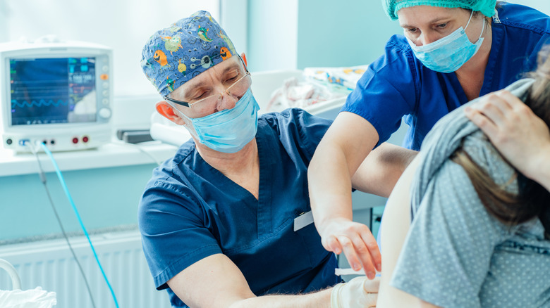 Patient receiving epidural from anesthesiologist 