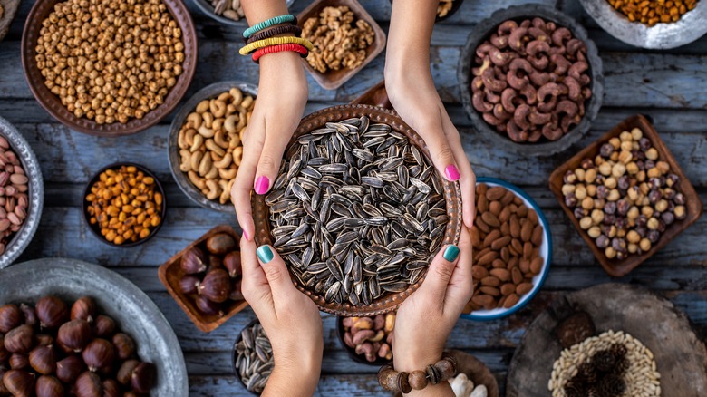 hands holding a bowl of sunflower seeds