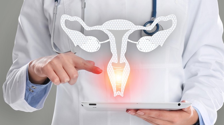 Doctor holding a tablet with a projected model of a uterus