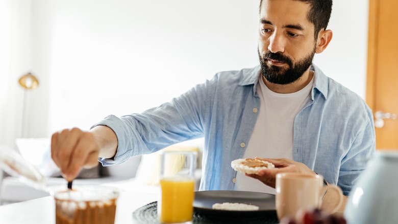 Man eating toast with peanut butter