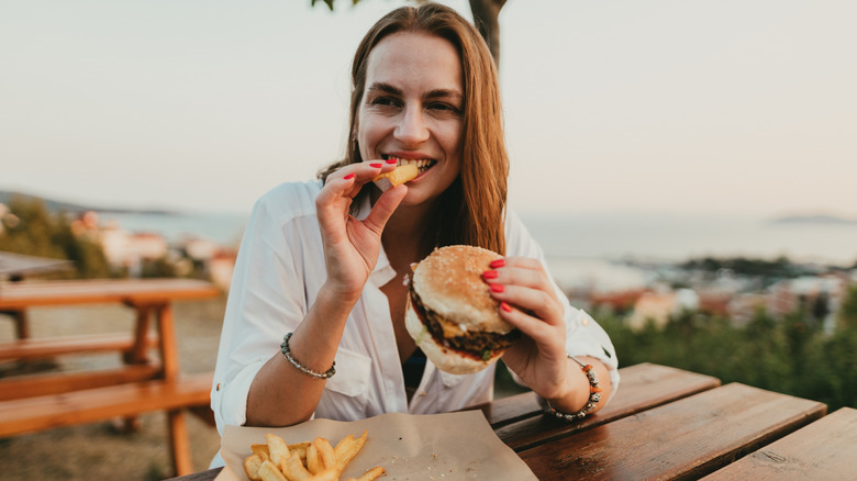 Woman eating burger and fries