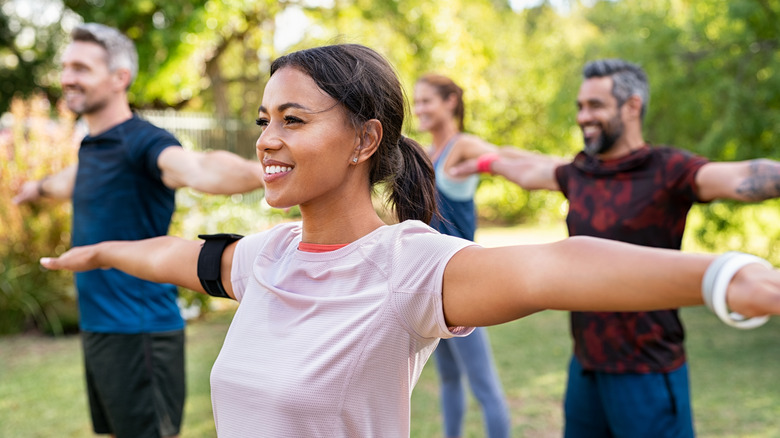 group of smiling people exercising 