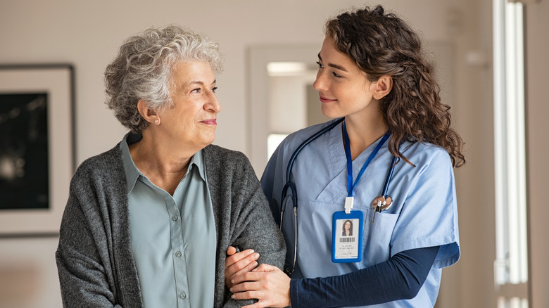 elderly woman assisted by medical professional