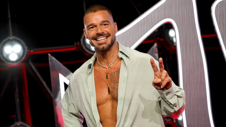 Ricky Martin makes a peace hand gesture while on stage at a public event