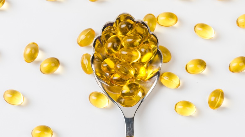 vitamin D capsules on spoon 