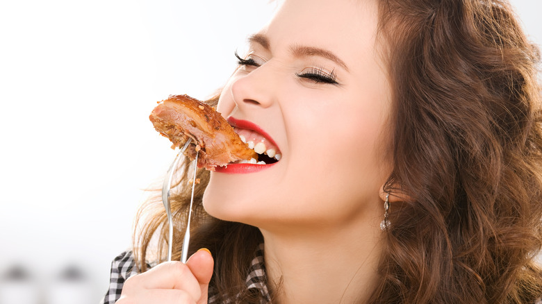 woman biting into a steak