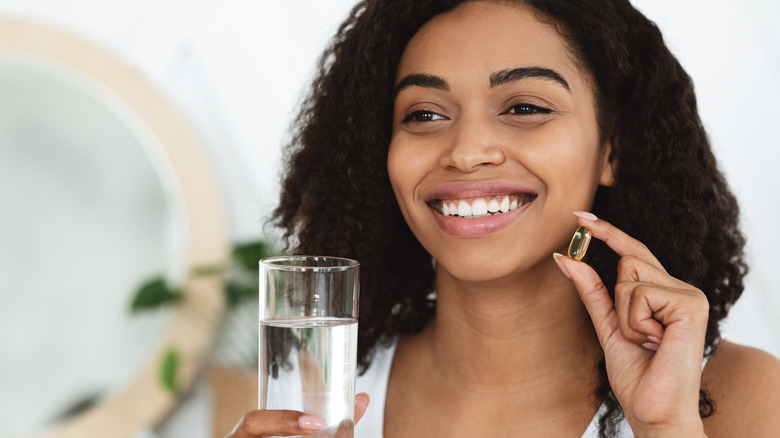 a woman taking a vitamin