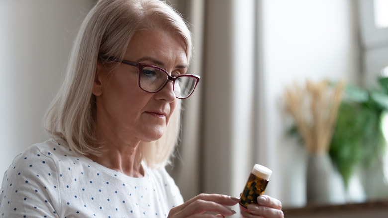 woman reading pills label