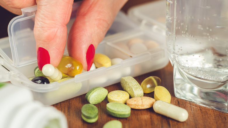 fingers picking up vitamins