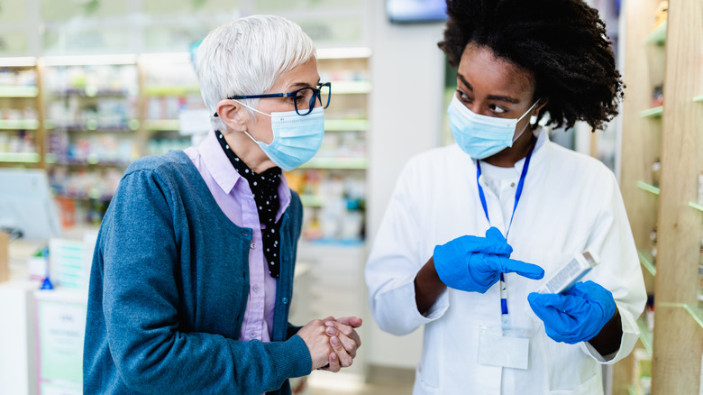 Healthcare professional speaking with senior at store