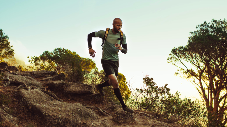 man trail running downhill 