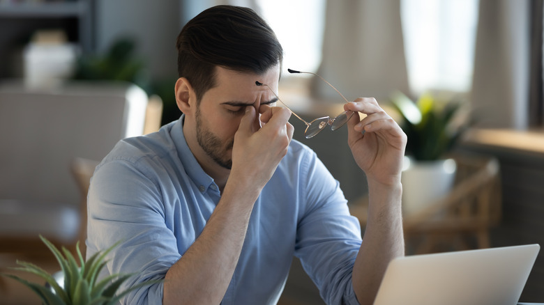 Man at computer suffering from fatigue and lack of concentration