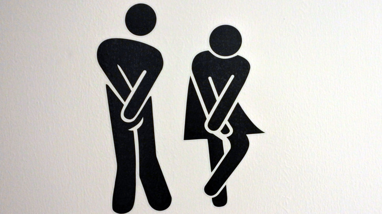 Typical bathroom sign for men and women with the pictures holding their hands over their bladder because they have to pee.