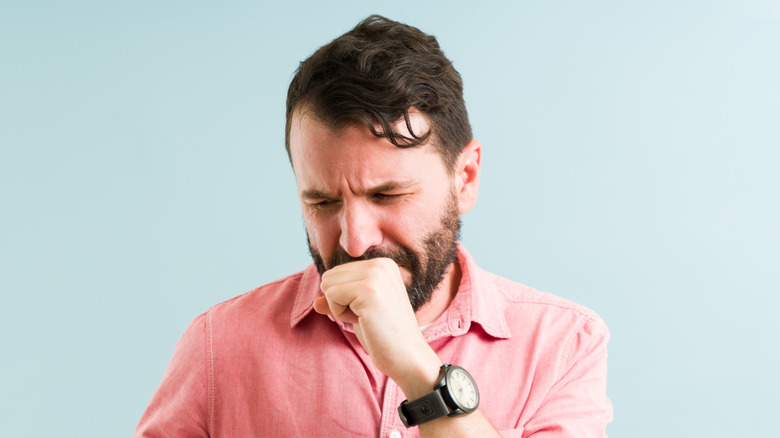 Nauseous man holding his hand to his mouth