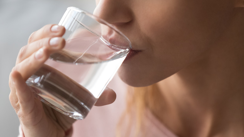 woman in pink drinking water