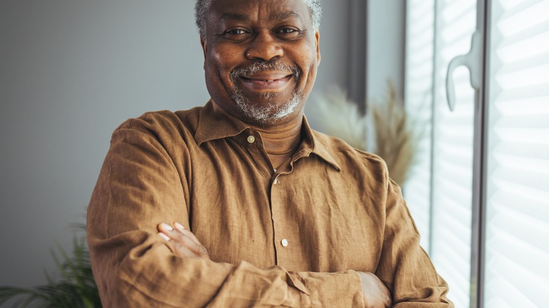 old man standing with crossed arms