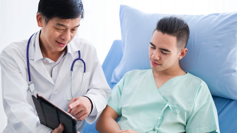 doctor discussing findings with male patient in hospital