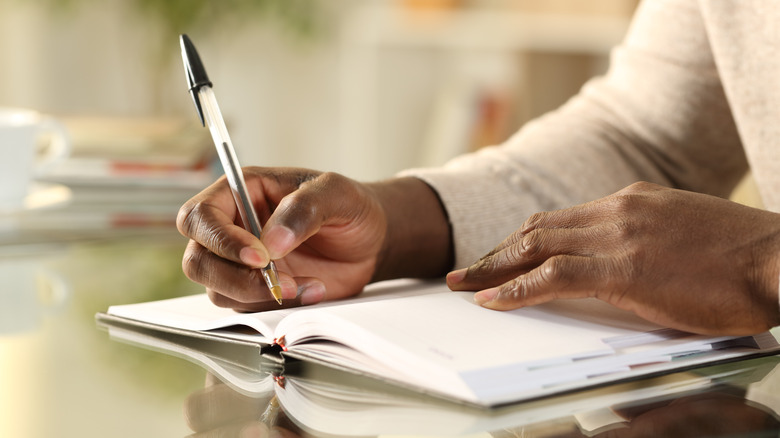 man writing in journal