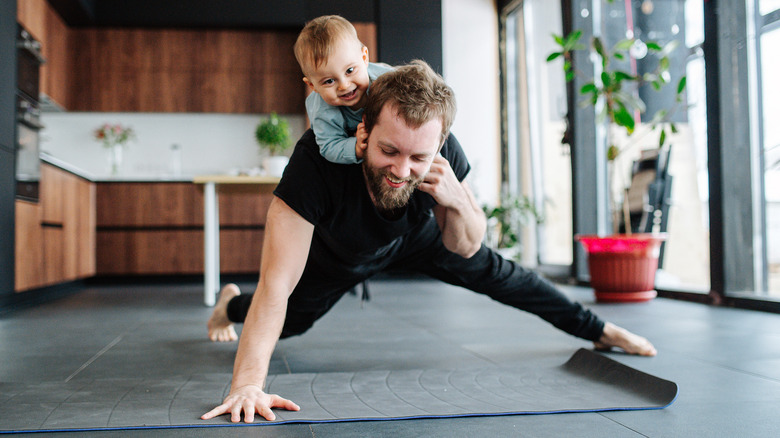 man working out with baby on back