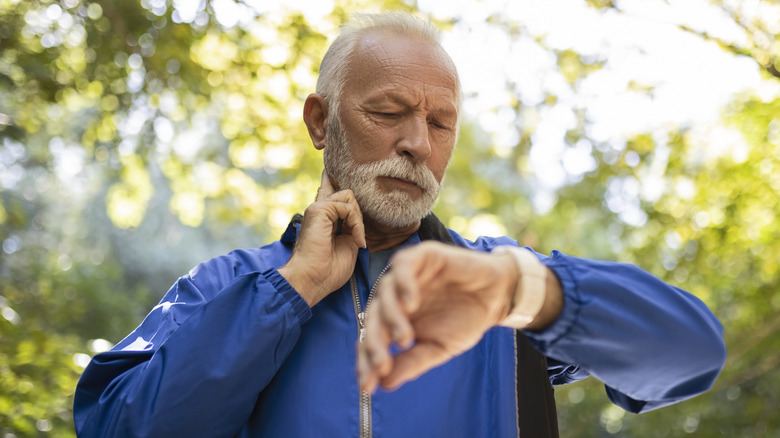 older man taking his pulse