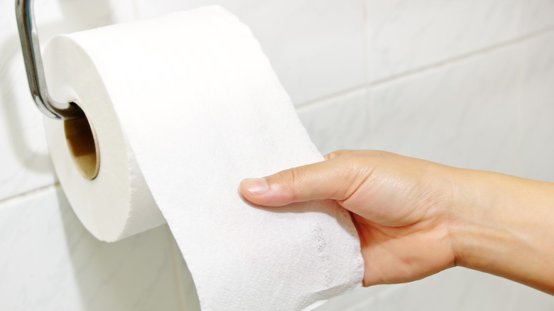 Woman tearing off toilet paper