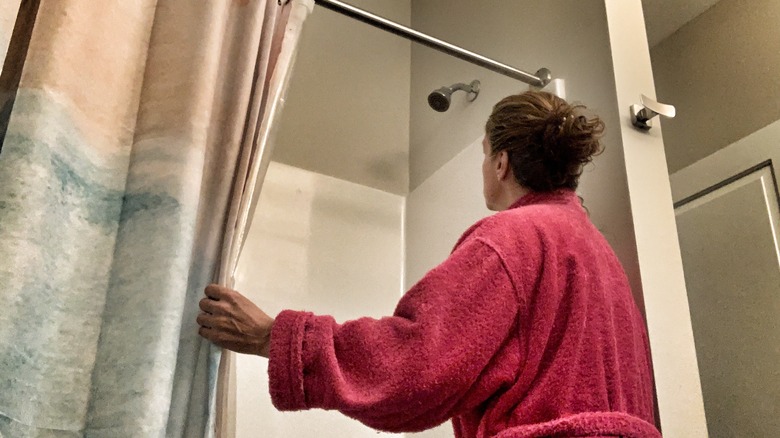 woman opening her shower curtain