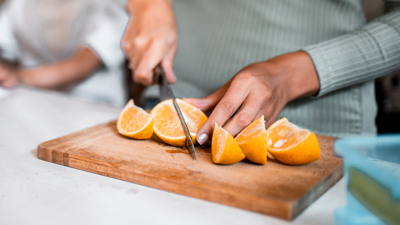 Woman slicing orange into wedges