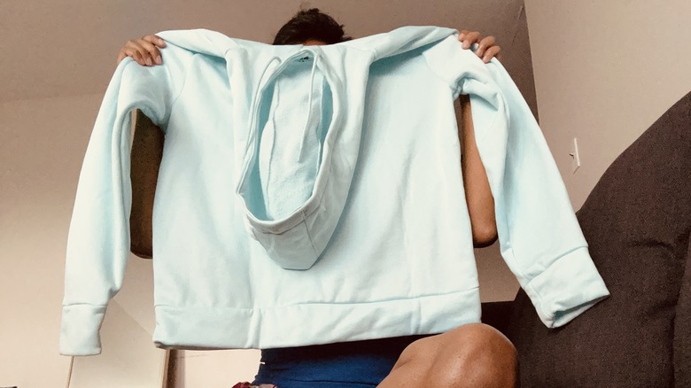 Holding up sweatshirt