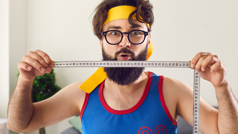Funny man holding measuring tape
