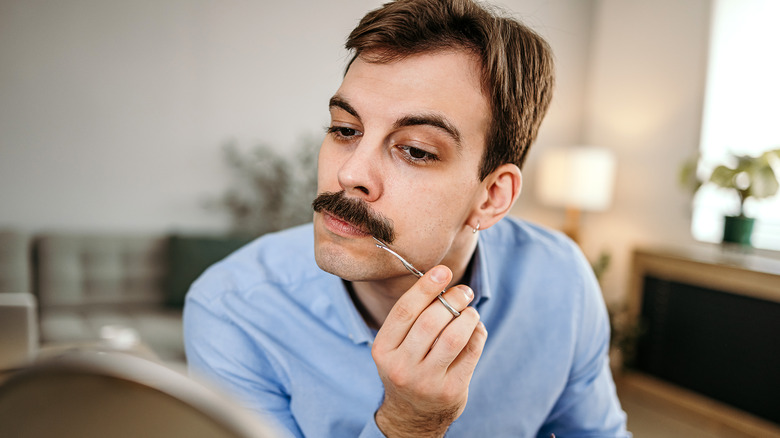 man trimming his mustache