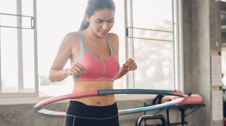 Woman using weighted hula hoop