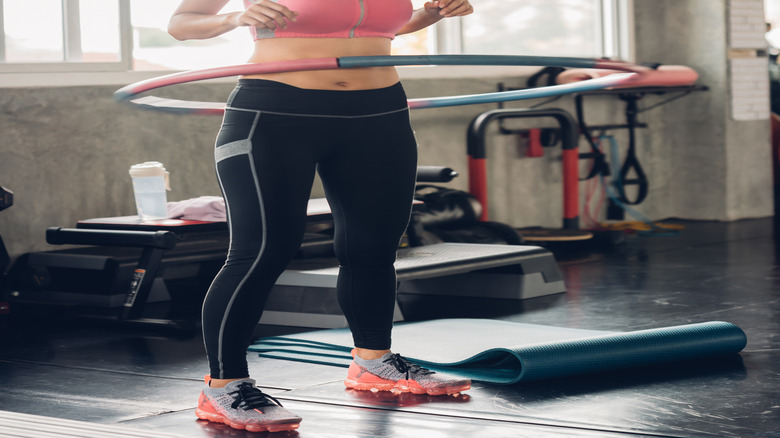 Woman using weighted hula hoop