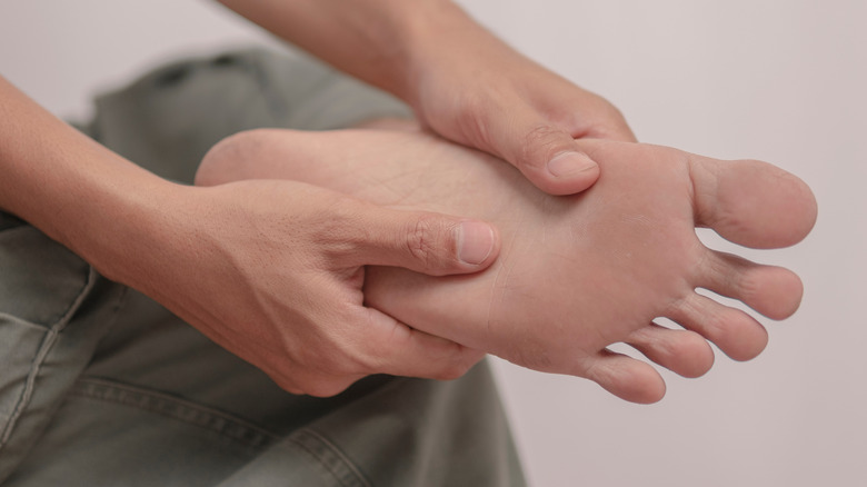 man holding his painful foot