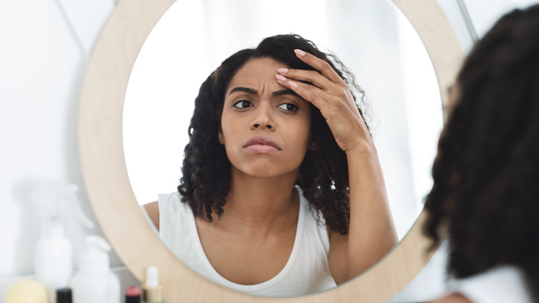 Woman looking at fine lines on face