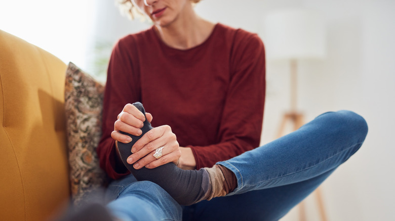 woman in pain holding toe