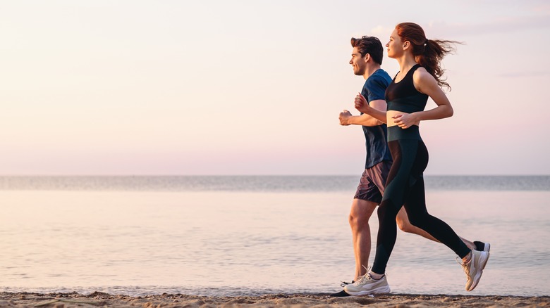 A couple runs on the beach