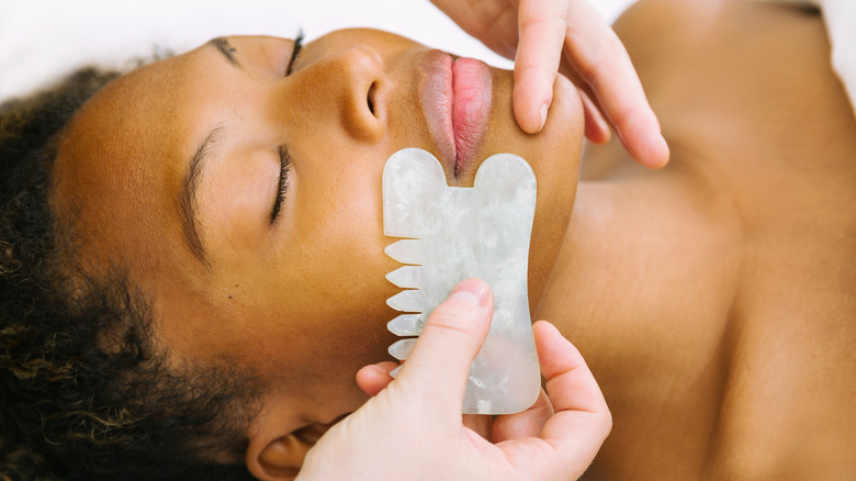 Jade comb against woman's face