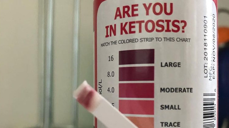 Close up of a keto strip and its color chart 