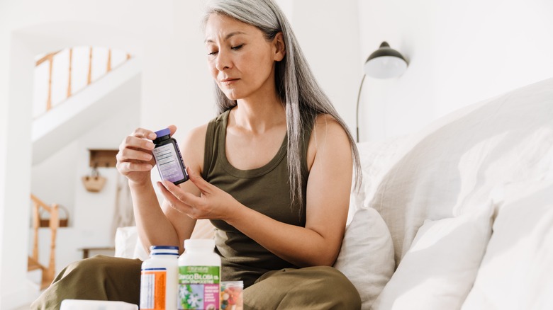 a woman reading a supplement label