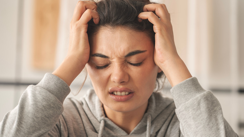 Woman itching her scalp