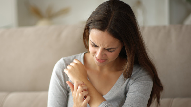 Woman itching her arm
