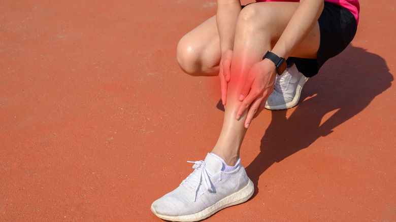 Woman holding her shin