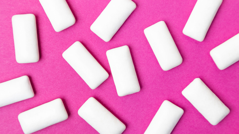 Pieces of sugar-free gum on pink background