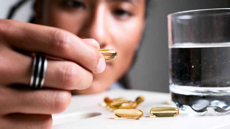 close up of a woman evaluating tanning pills 